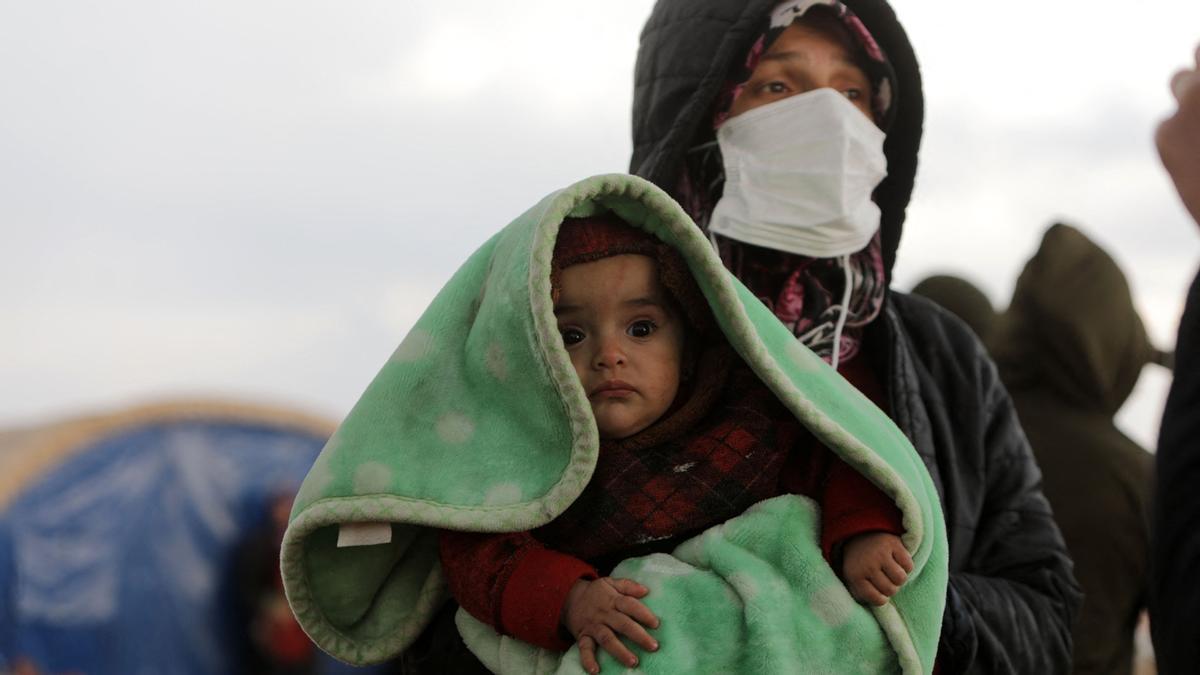 Una mujer con su bebé observa las operaciones de búsqueda en la ciudad de Jindayris días después que un terremoto mortal azotara Turquía y Siria   