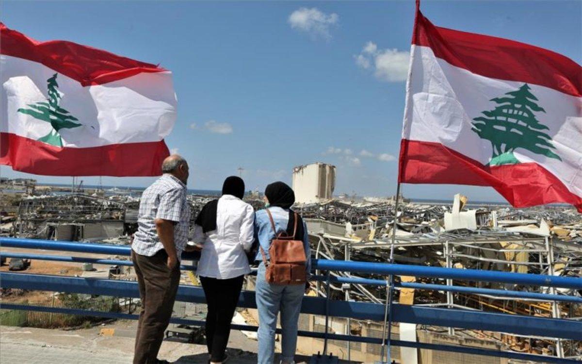 Personas observan la destrucción que dejó la explosión en el puerto de Beirut, Líbano.