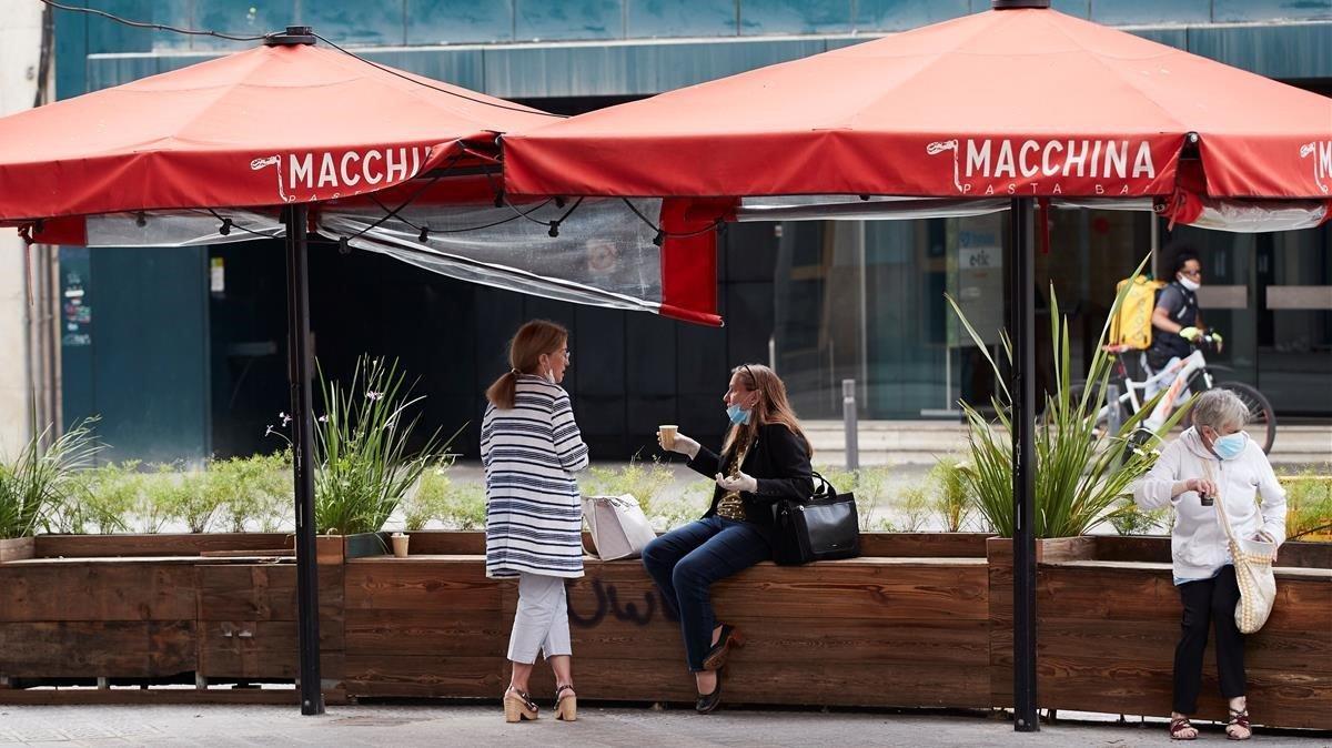 Varias personas toman café en una terraza cerrada de Barcelona, en mayo.
