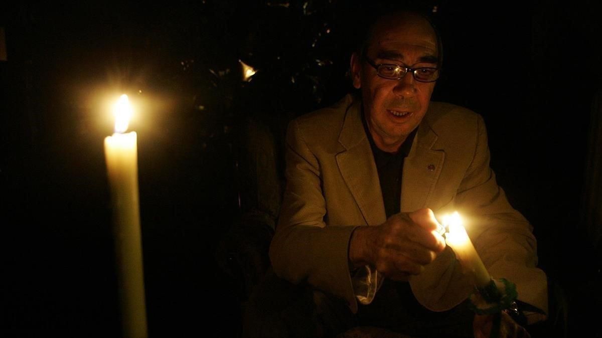 Un hombre sin luz en su casa enciende unas velas Un hombre sin luz en su casa enciende unas velas