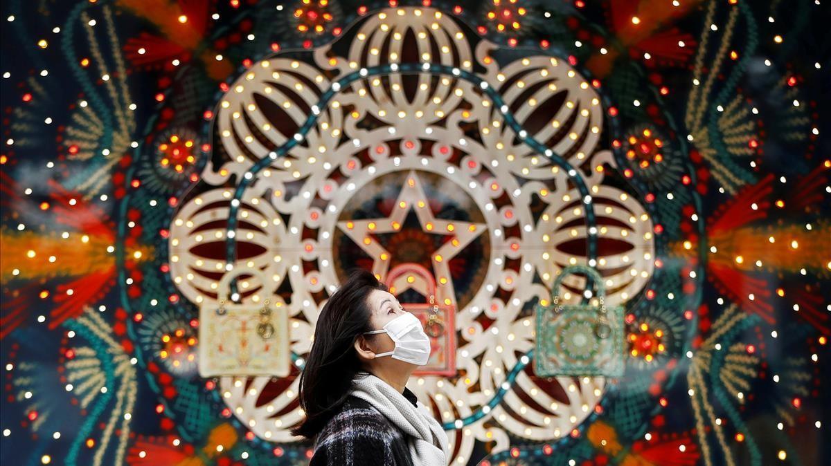 Una mujer pasa junto unas decoraciones navideñas en el barrio comercial de Ginza, en Tokio.
