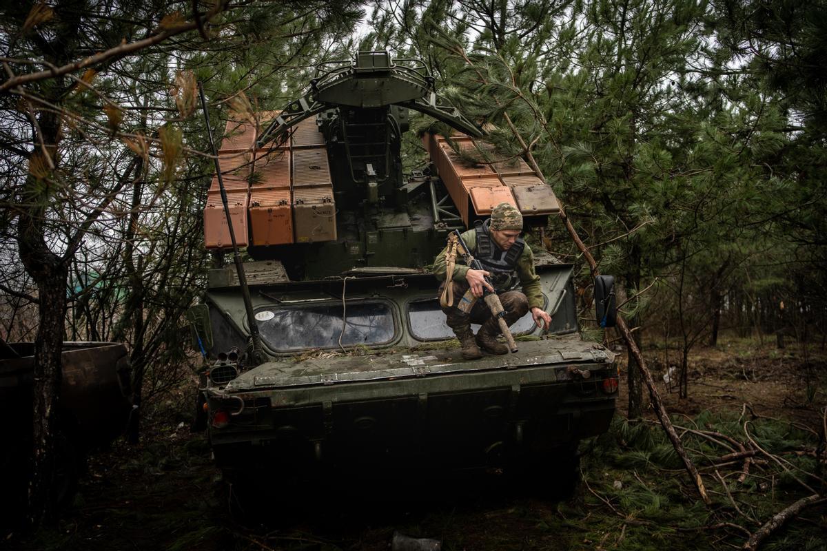 Un miembro de la batería desciende de un 9K33 Osa en un bosque del Donbás.