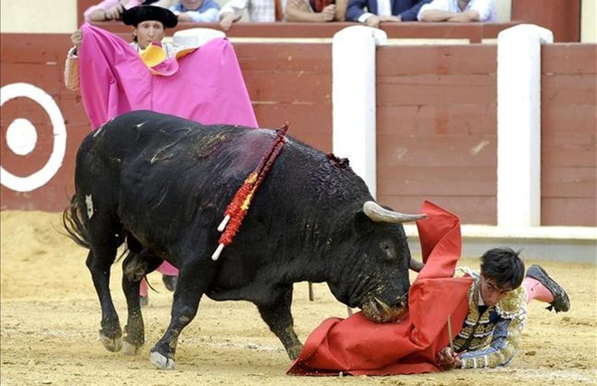  El diestro Saúl Jiménez Fortes escapa de la cara de su primer toro, en la primera corrida de la Feria de la Virgen de San Lorenzo de Valladolid.