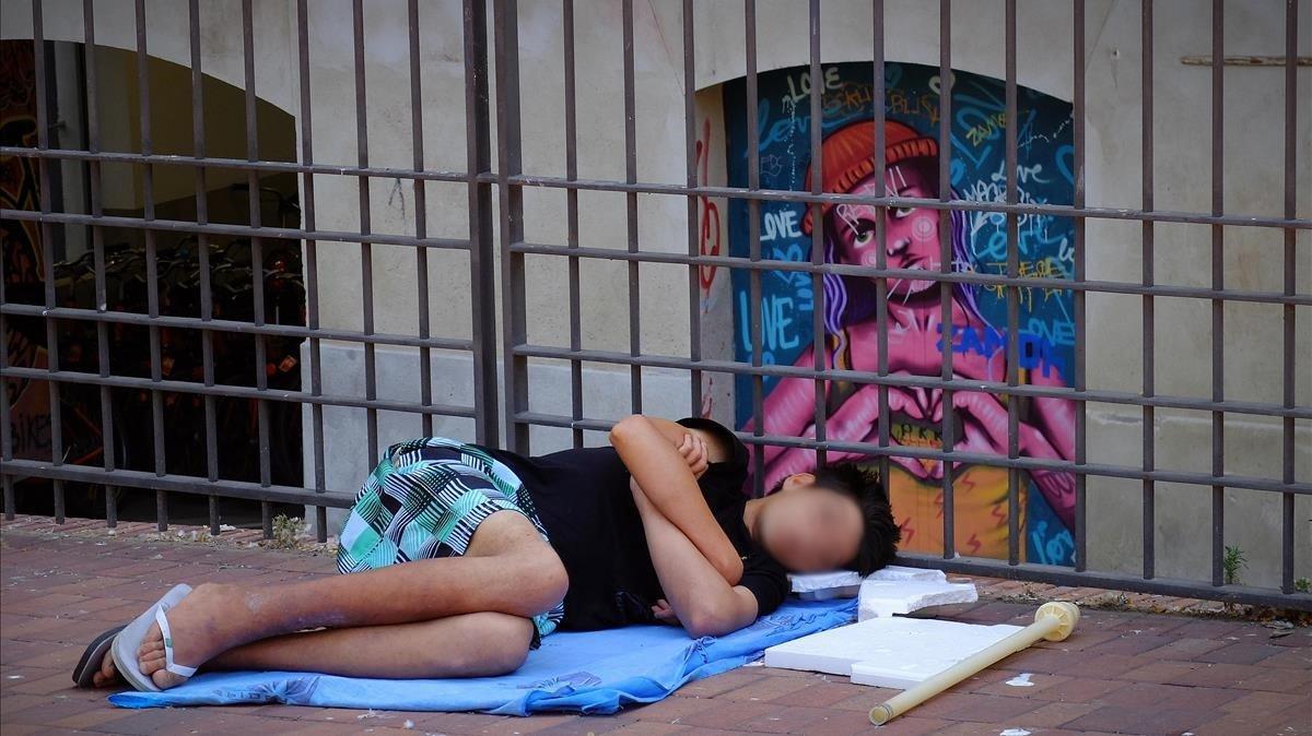Un menor duerme en un parque de Barcelona, el viernes 5 de junio por la mañana.