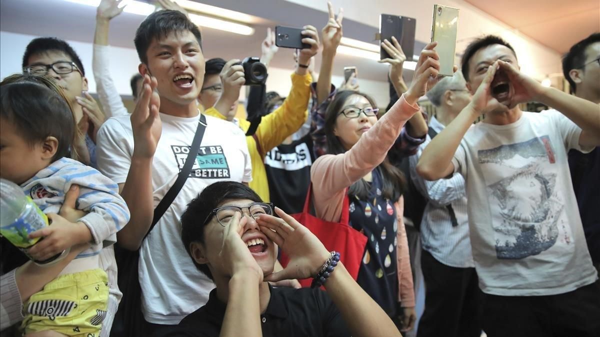Jóvenes antigubernamentales celebran el resultado de las elecciones en Hong Kong, este domingo. Jóvenes antigubernamentales celebran el resultado de las elecciones en Hong Kong, este domingo.