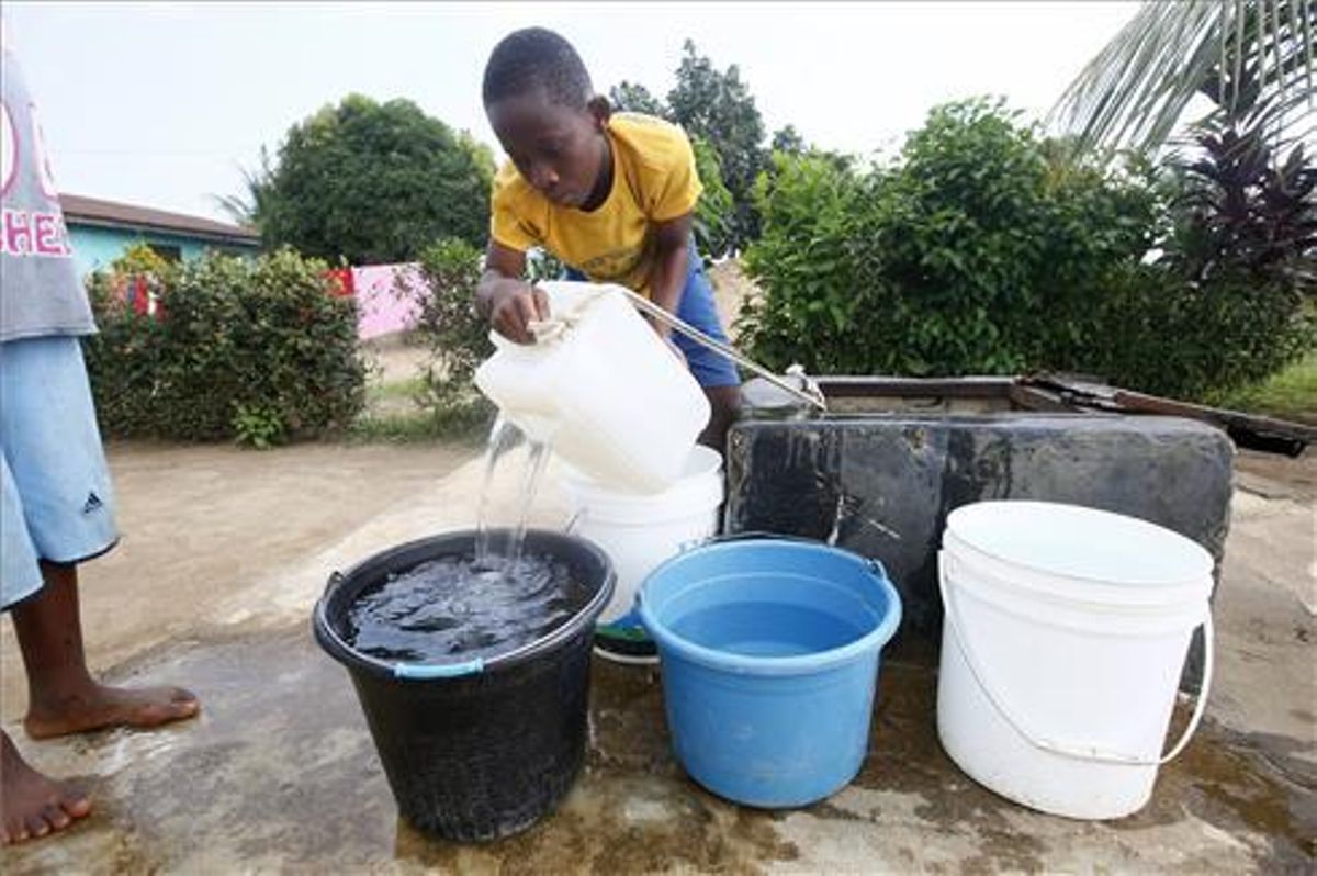 Un niño saca agua de un pozo situado en Johnsonville Commuity, a las afueras de Monrovia, Liberia Un niño saca agua de un pozo situado en Johnsonville Commuity, a las afueras de Monrovia, Liberia
