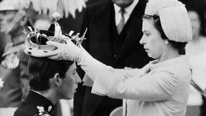 La reina Isabel II coloca la corona a su hijo, el príncipe Carlos, durante su investidura como príncipe de Gales, el 1 de julio de 1969.
