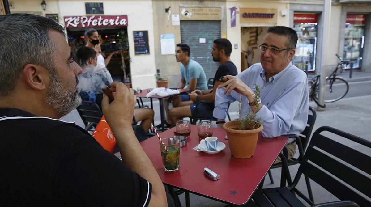 Dos hombres fuman sendos puros en una terraza de Barcelona, sin respetar la distancia de seguridad, este viernes 14 de agosto. Dos hombres fuman sendos puros en una terraza de Barcelona, sin respetar la distancia de seguridad, este viernes 14 de agosto.