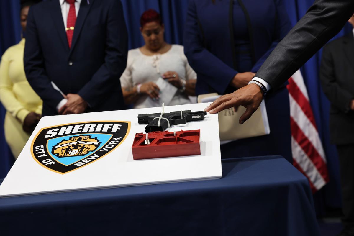  El alcalde de la ciudad de Nueva York, Eric Adams, toca un arma durante una conferencia de prensa con la fiscal general de Nueva York, Letitia James