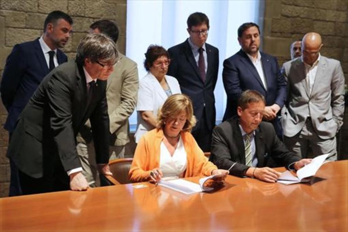 Borràs lee la notificación de la querella en presencia de Puigdemont. Borràs lee la notificación de la querella en presencia de Puigdemont.