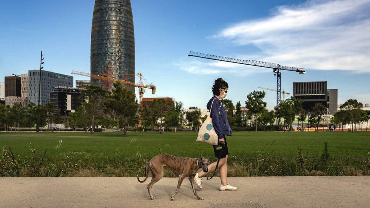 Una mujer pasea el perro por un parque de Barcelona. Una mujer pasea el perro por un parque de Barcelona.