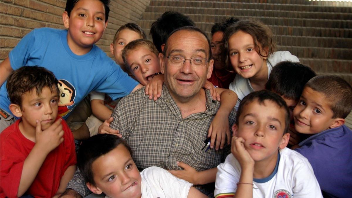 El pare Manel rodeado de niños a los que atendía en Nou Barris, en el 2004.