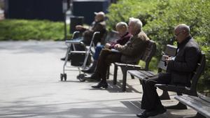 Unos pensionistas se relajan en un parque. 