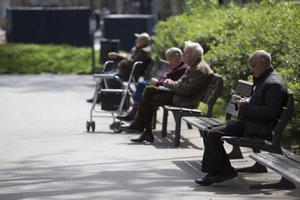 Unos pensionistas se relajan en un parque. 