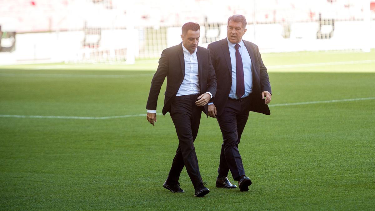 Xavi y Laporta caminan por el césped del Camp Nou.