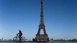 Un niño circula en bicicleta por los alrededores de la Torre Eiffel 