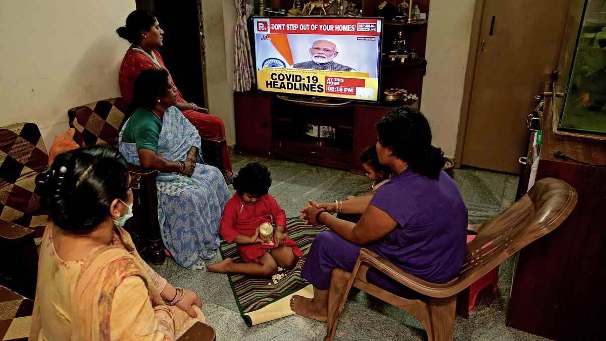 La India confina a sus 1.300 millones de habitantes para frenar el coronavirus. Una familia de Bangalore escucha el mensaje del primer ministro Indio que ordena el confinamiento por el coronavirus. 