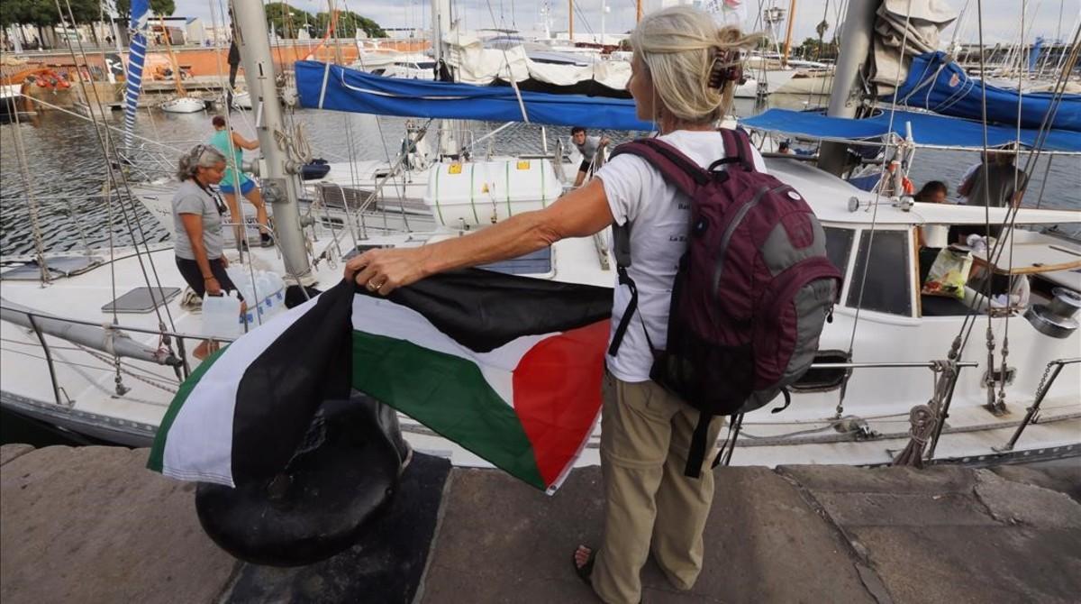 Una activista con la bandera palestina frente a uno de los dos veleros de la flotilla que ha partido hacia Gaza. Una activista con la bandera palestina frente a uno de los dos veleros de la flotilla que ha partido hacia Gaza.