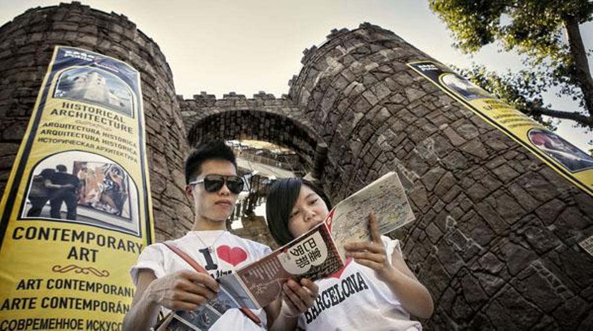 Una pareja de turistas, en la puerta del Poble Espanyol. Una pareja de turistas, en la puerta del Poble Espanyol.