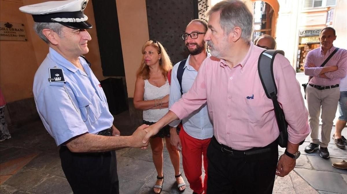 El nuevo alcalde de Génova, el conservador Marco Bucci (centro), saluda a un policía local a su llegada al Palazzo Tursi, sede de la alcaldía de Génova, el 26 de junio. El nuevo alcalde de Génova, el conservador Marco Bucci (centro), saluda a un policía local a su llegada al Palazzo Tursi, sede de la alcaldía de Génova, el 26 de junio.