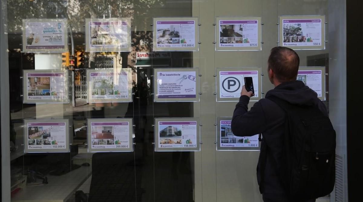 Un hombre mira la oferta de pisos en una inmobiliaria de Barcelona. Un hombre mira la oferta de pisos en una inmobiliaria de Barcelona.