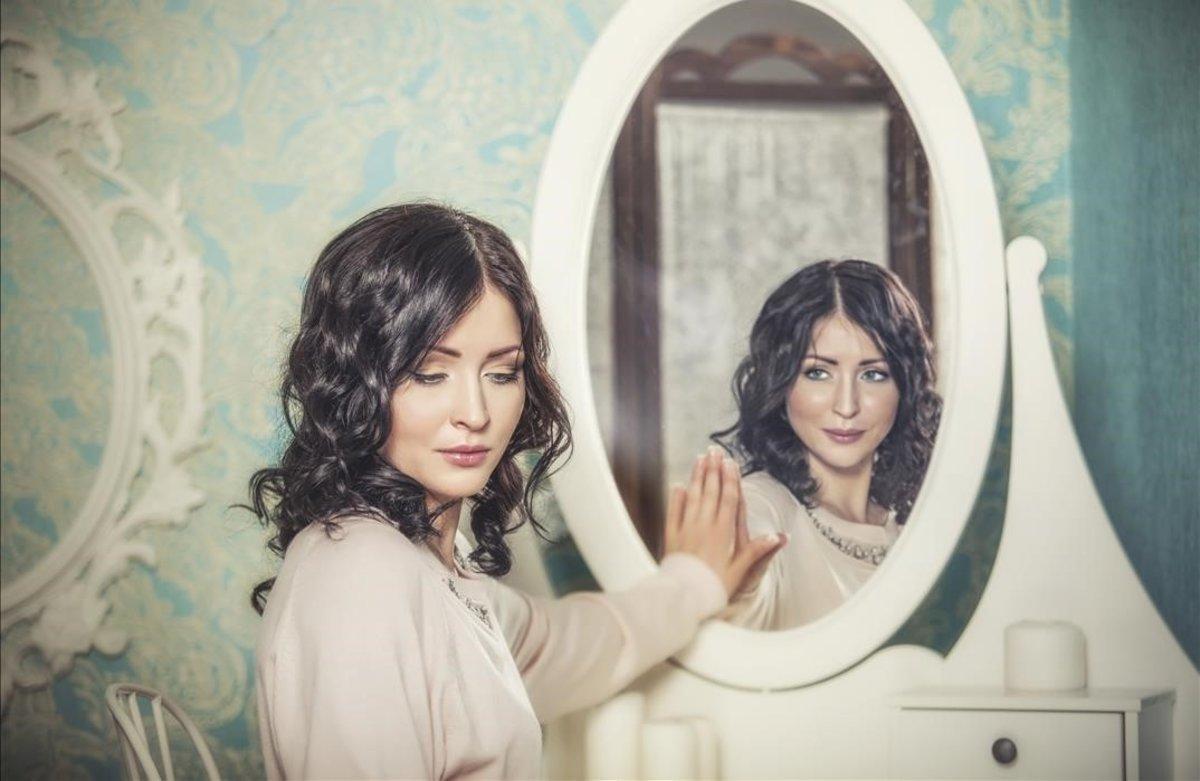 Una mujer reflejada en un espejo.