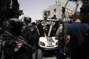 Soldados israelís vigilan de cerca el funeral por la periodista palestina muerta por fuego israelí en Jerusalén.