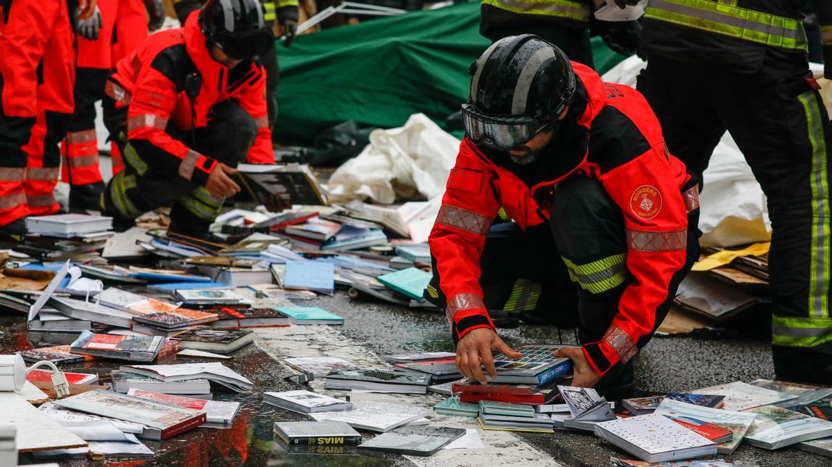 Bomberos de Barcelona recogiendo libros mojados, tras la tormenta en el Paseo de Gracia el día de Sant Jordi 2022