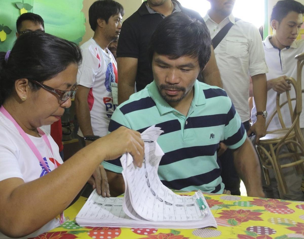 El boxeador Emmanuel Manny Pacman Pacquiao (d) ejerce su derecho al voto en Kiam.