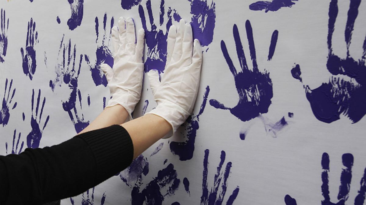 Una pared con manos lilas pintadas en un acto feminista