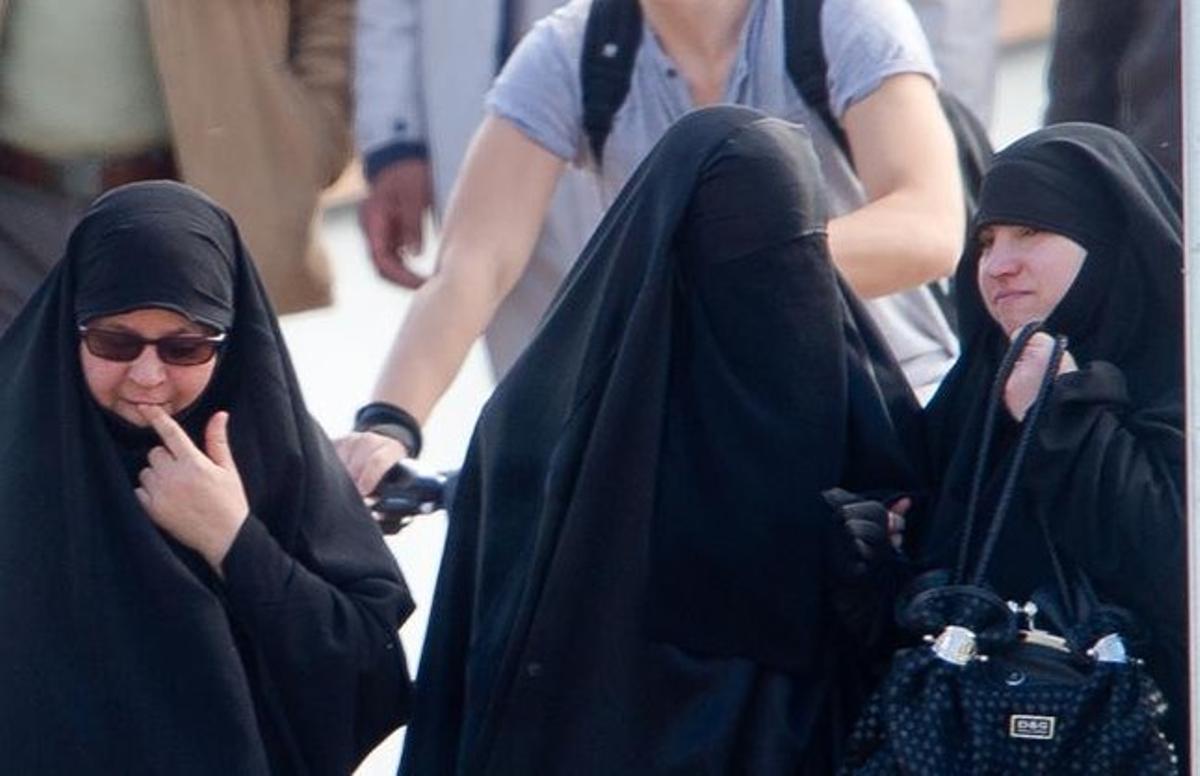 Una mujer con niqab (centro) junto a otras dos musulmanas con velo en Lleida.