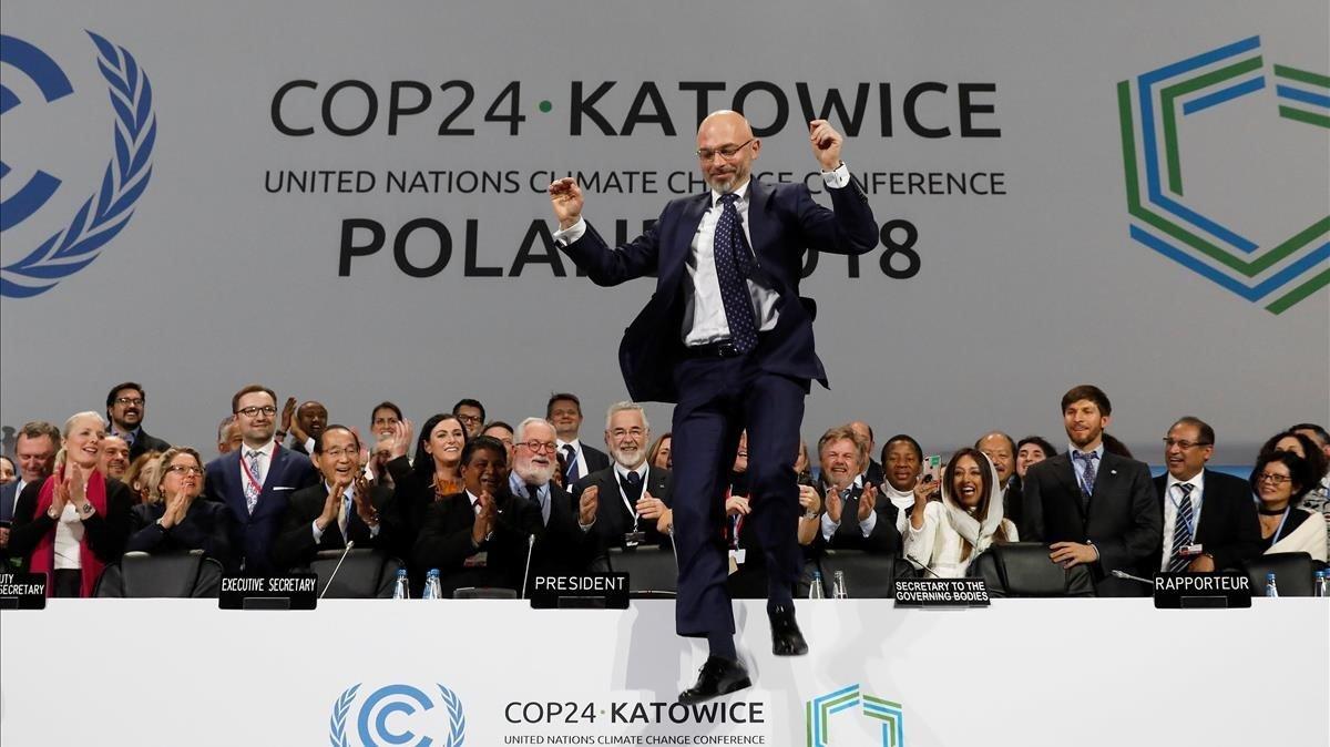 El ministro polaco de Medio Ambiente y presidente de la cumbre, Mychal Kutyka, da un salto tras sellarse el acuerdo en Katowice.