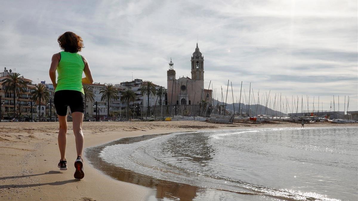 Una mujer hace ejercicio en la playa de Sitges, el pasado día 4.