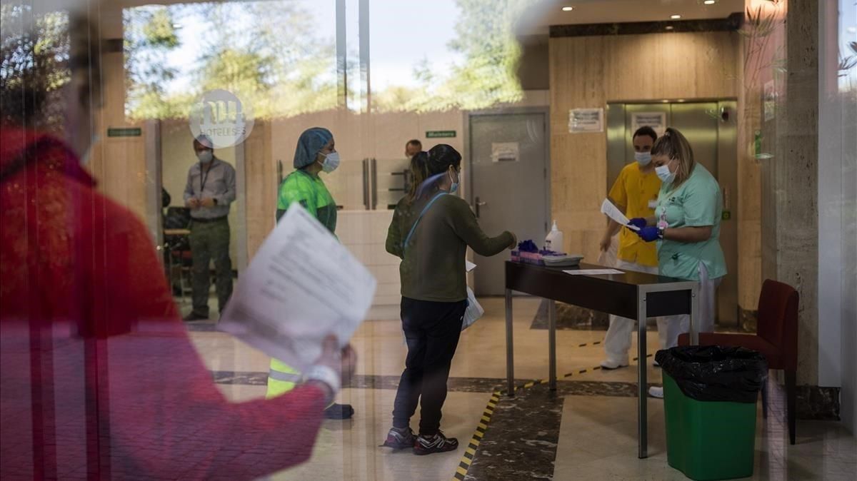 Una enfermera (derecha) recibe a una paciente con covid-19 en un hotel en Leganés para que pase la cuarentena, este jueves. Una enfermera (derecha) recibe a una paciente con covid-19 en un hotel en Leganés para que pase la cuarentena, este jueves.