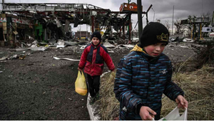 Dos niños abandonan la ciudad de Irpin, al noroeste de Kiev, tras intensos bombardeos en la zona.