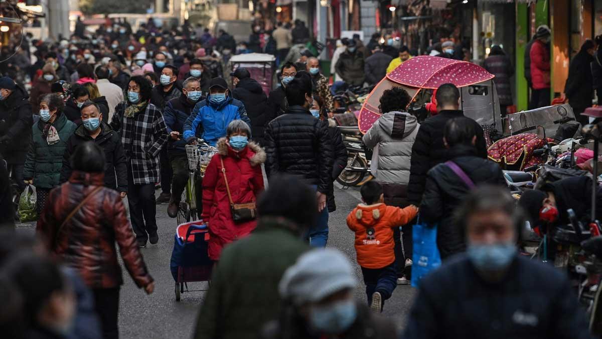 Gente por una céntrica calle, cerca del mercado de Wuhan.