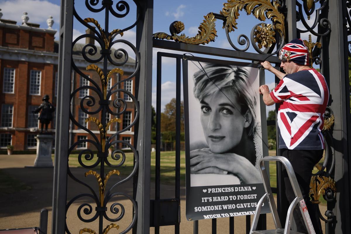 Un fan de Diana, John Loughrey, cuelga un cartel de la princesa en la puerta del Palacio de Kensington en Londres, Gran Bretaña, este viernes. Un fan de Diana, John Loughrey, cuelga un cartel de la princesa en la puerta del Palacio de Kensington en Londres, Gran Bretaña, este viernes.