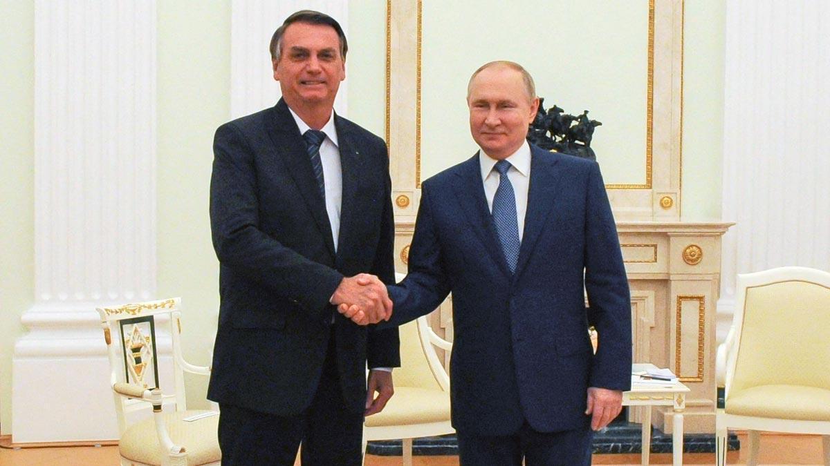 Jair Bolsonaro y Vladimir Putin se saludan.