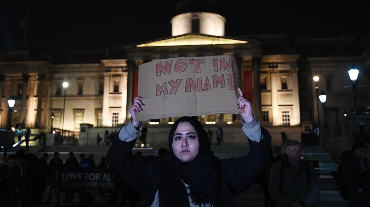 Una mujer musulmana con el cartel ’No en mi nombre’ en la concentración de Trafalgar Square.