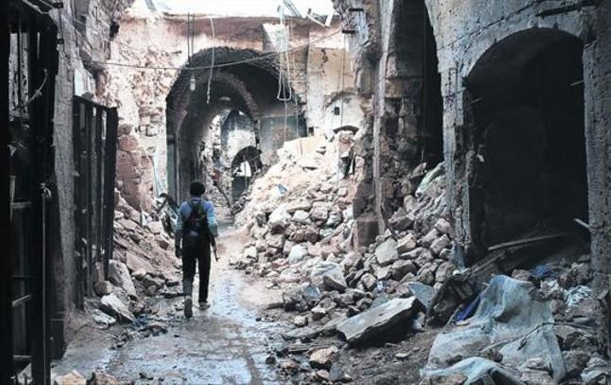 Un miliciano camina por entre las ruinas que han dejado los bombardeos en el zoco antiguo de Alepo, una ciudad habitada desde hace 7.000 años. Un miliciano camina por entre las ruinas que han dejado los bombardeos en el zoco antiguo de Alepo, una ciudad habitada desde hace 7.000 años.