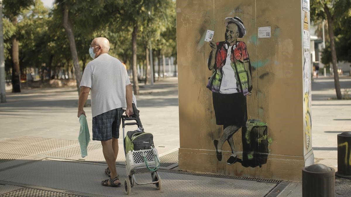 Un hombre pasa delante del dibujo de TVboy del rey emérito Juan Carlos I en el parque de la Barceloneta, este jueves. Un hombre pasa delante del dibujo de TVboy del rey emérito Juan Carlos I en el parque de la Barceloneta, este jueves.