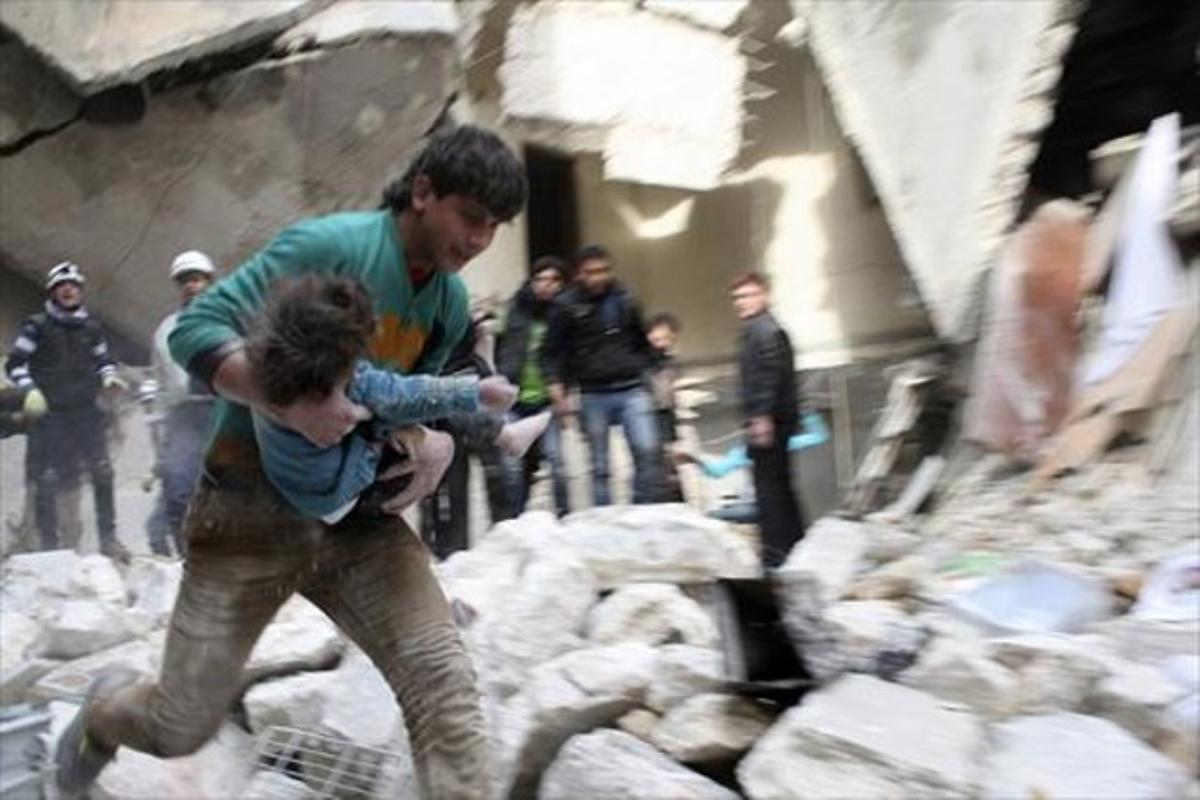 Un hombre traslada a una niña herida tras un bombardeo en Alepo.