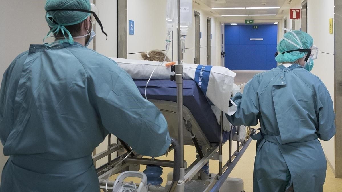 Dos sanitarios trasladan a un paciente de covid-19. Dos sanitarios trasladan a un paciente de covid-19.