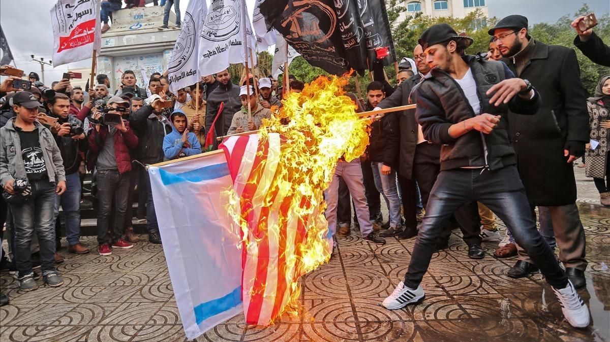Manifestantes palestinos queman banderas de EEUU e Israel en Gaza. Manifestantes palestinos queman banderas de EEUU e Israel en Gaza.