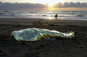 El cuerpo de un migrante fallecido en un naufragio en el mar yace en una playa de Fuerteventura.