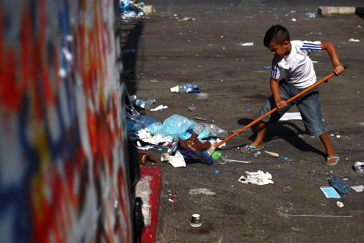 Un niño limpia en la plaza de los Mártires de Beirut, donde el sábado hubo protestas contra el Gobierno. Un niño limpia en la plaza de los Mártires de Beirut, donde el sábado hubo protestas contra el Gobierno.