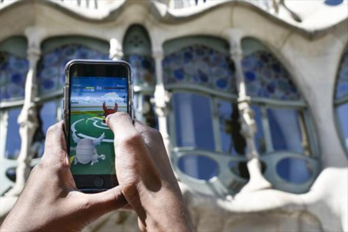 Un usuario de Pokémon Go juega frente a la Casa Batlló de Barcelona, un día antes de la salida oficial de la aplicación en España.
