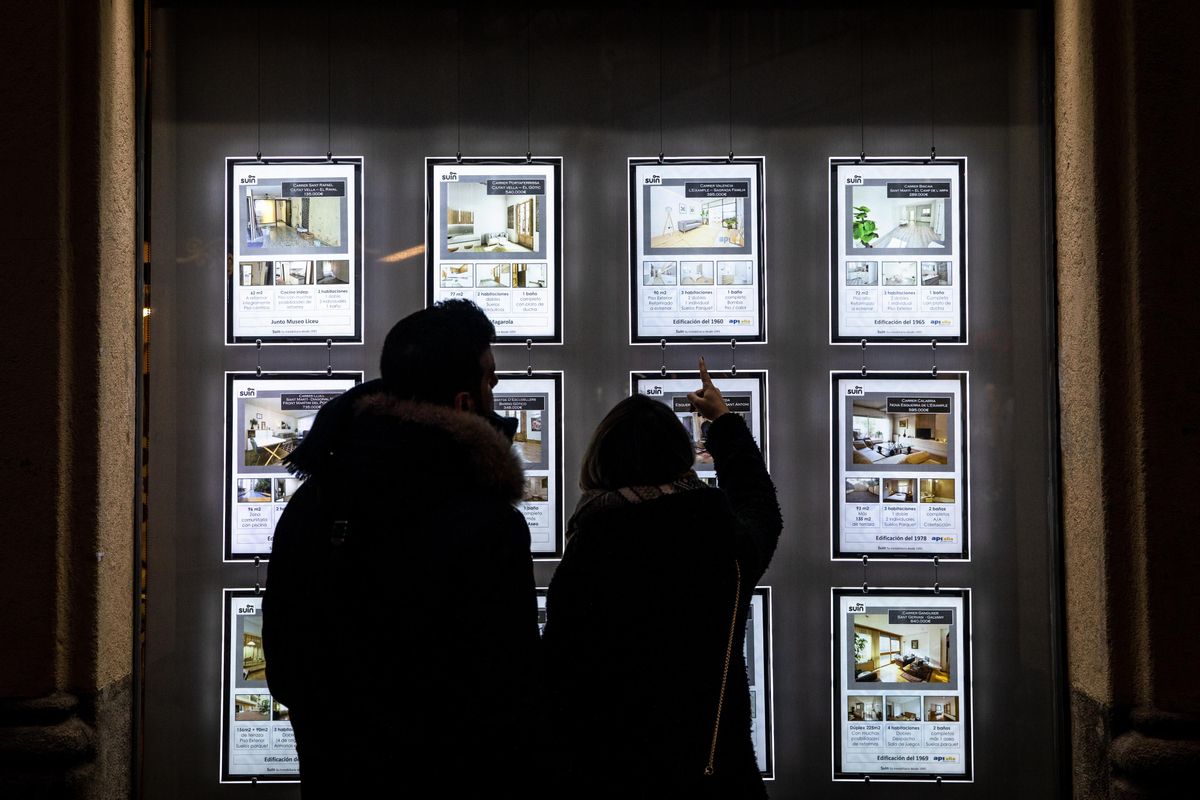 Imagen de unos jóvenes mirando pisos en el escaparate de una inmobiliaria Imagen de unos jóvenes mirando pisos en el escaparate de una inmobiliaria