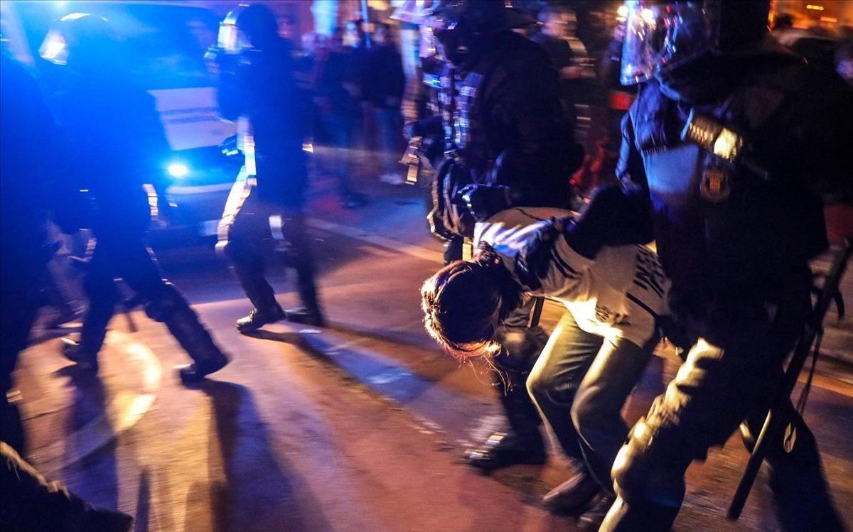 Un manifestante, detenido por los Mossos durante la protesta en Barcelona por el clásico Barça-Madrid, este miércoles.