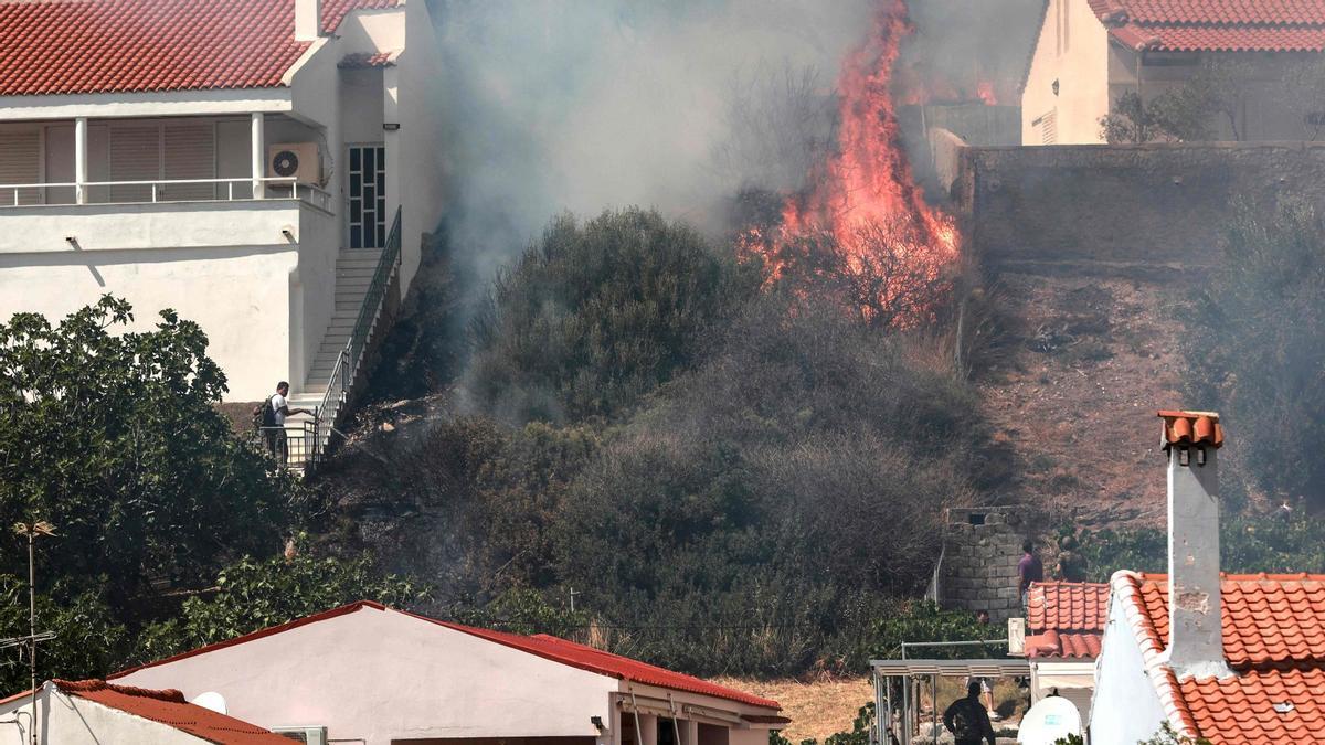 Varias personas miran el avance de las llamas en la isla griega de Lesbos, este sábado.